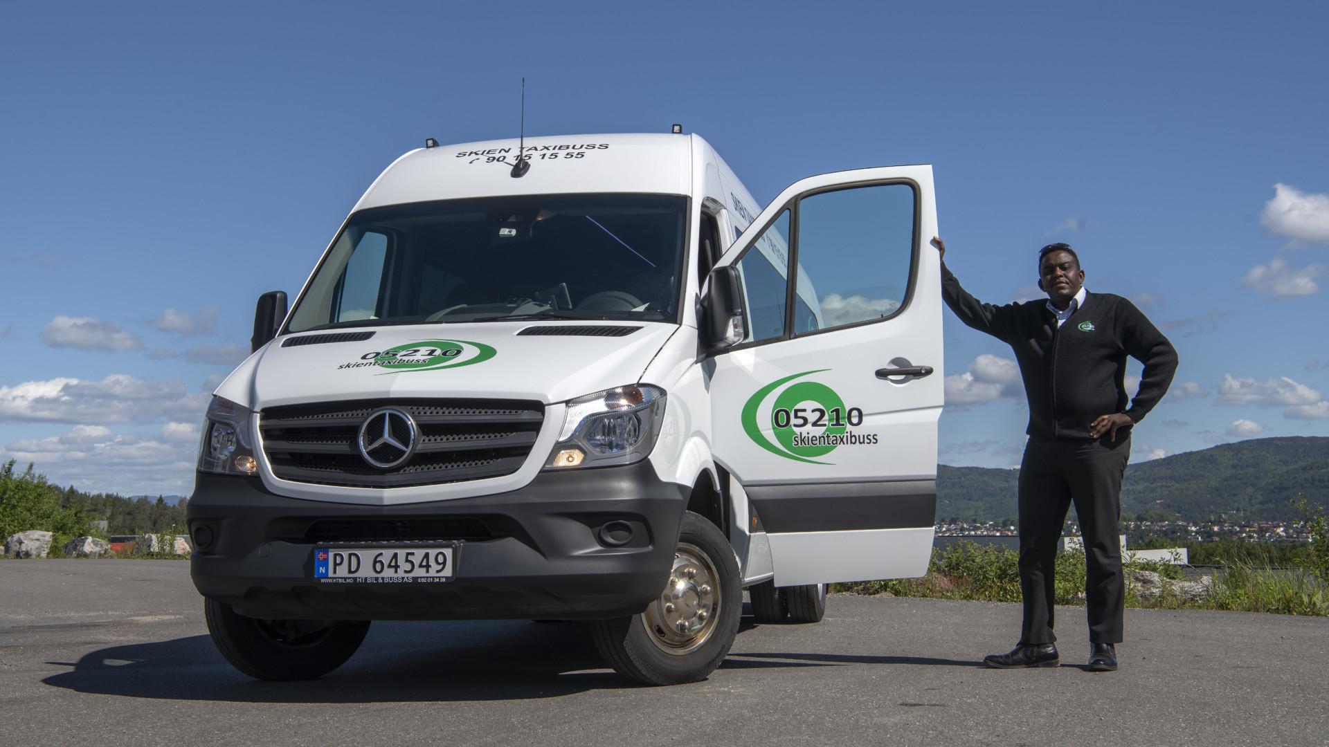 En mann står ved siden av en hvit Mercedes varebil med åpen dør, med logoen S2 på siden.