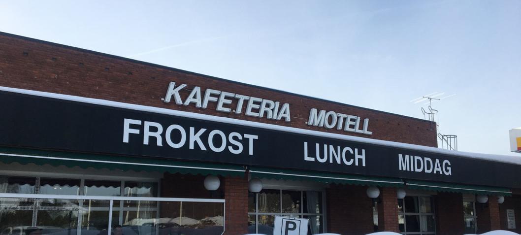 Kafeteria og motell med skilt for frokost, lunsj og middag på en solfylt dag.