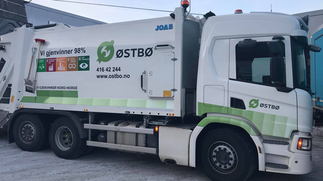 Avfallsbil fra Østbø med logo og informasjon om resirkulering, parkert på en gate.