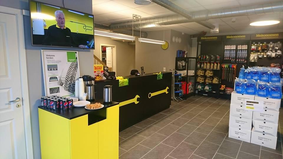 Moderne butikkinteriør med svart og gult design, kaffemaskin, snacks og produkter på hyllene.