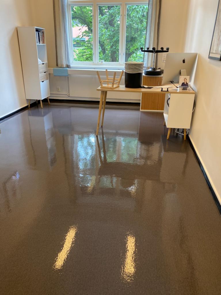 Moderne rom med glanset gulv, vindu med utsikt, og møbler som inkluderer et bord og skap.