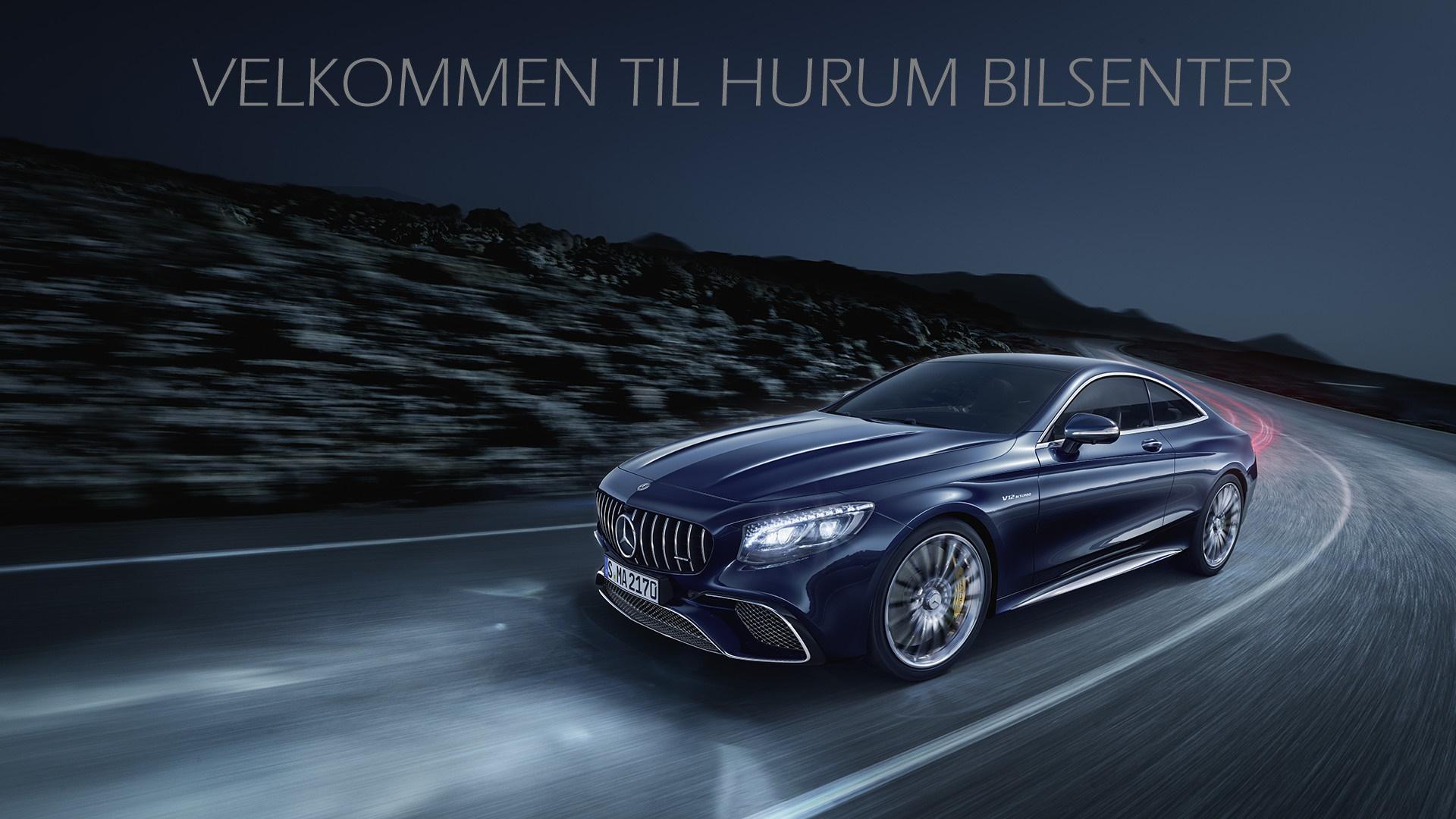 En mørk luksusbil kjører på en svingete vei med fjell i bakgrunnen, med teksten "Velkommen til Hurum Bilsenter".