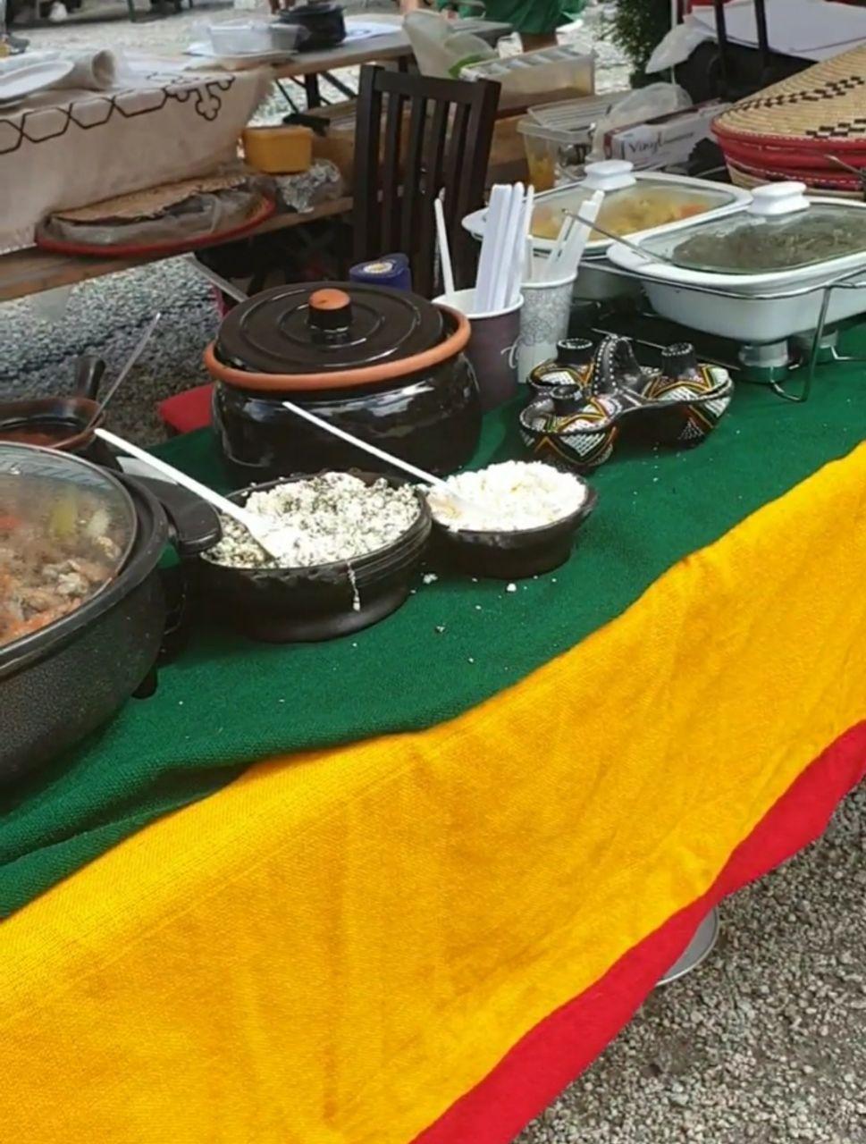 Et bord med forskjellige retter, inkludert salater og gryteretter, dekket med en fargerik duk.