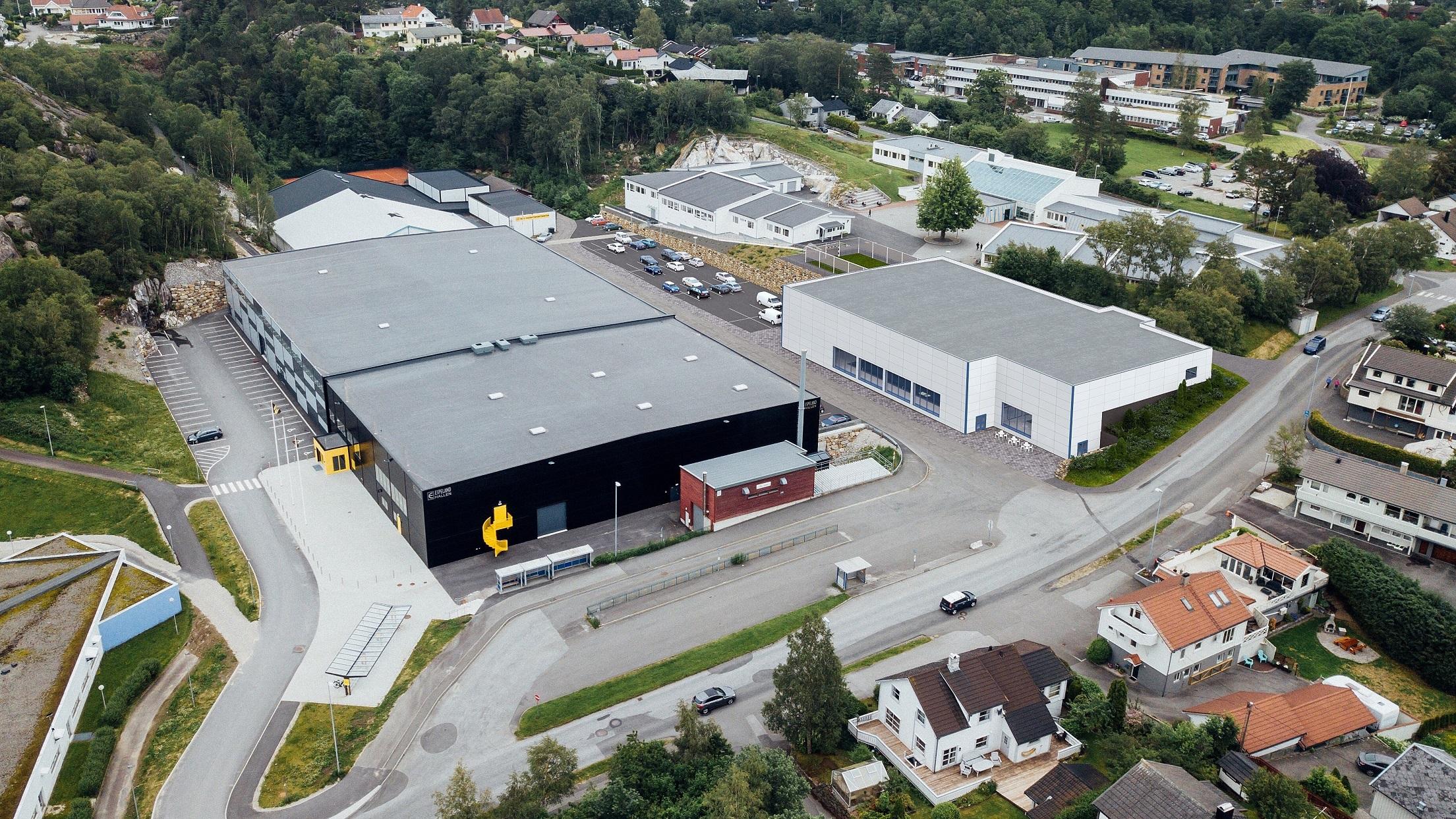 Oversiktsbilde av et industriområde med store lagerbygninger og veier i nærheten av boligområder.