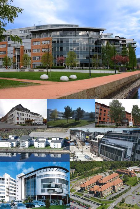 Moderne bygninger og kontorlandskap i en by, med grøntområder og parkerte biler.