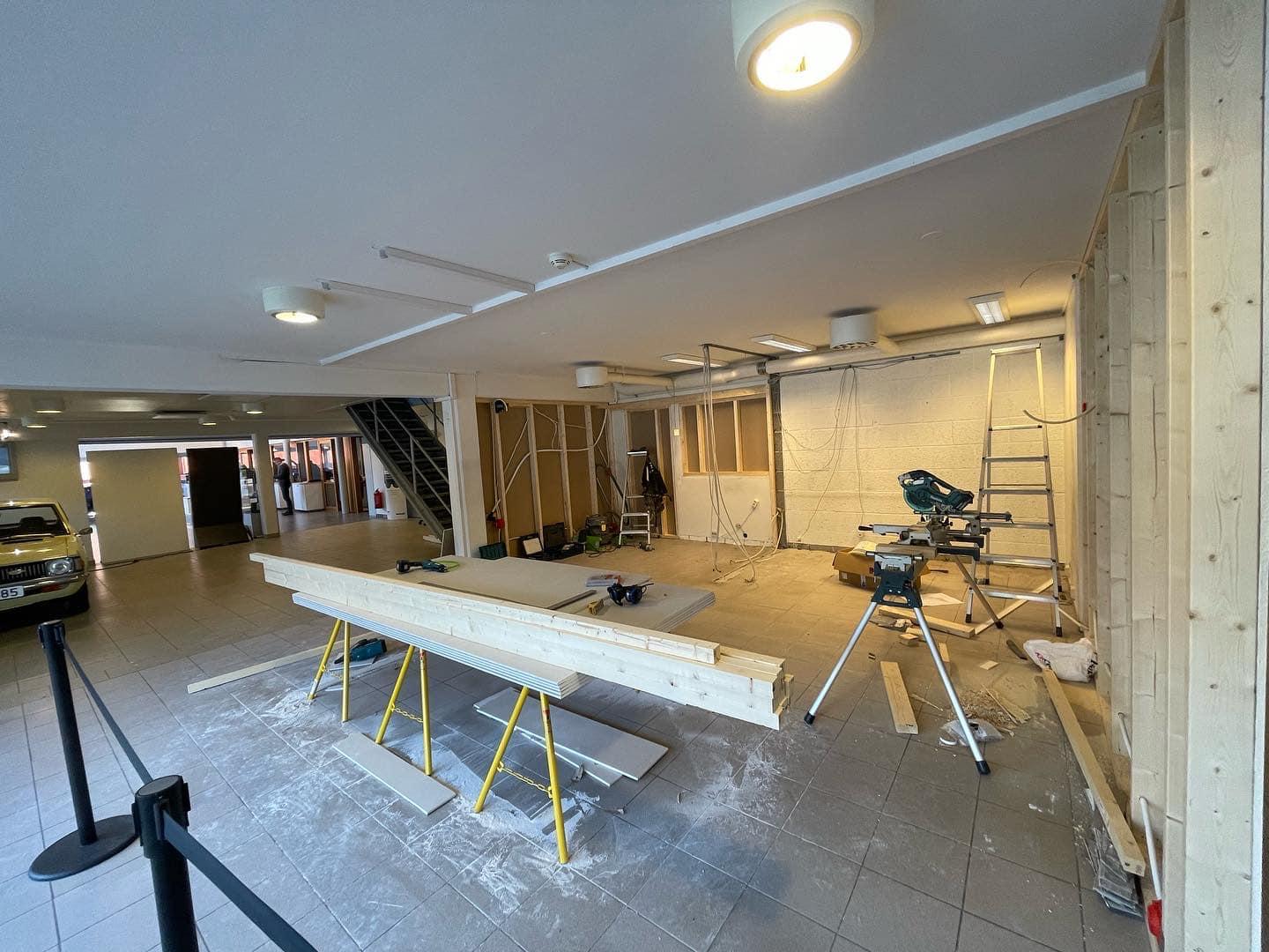 Renovering av et rom med byggeutstyr, treplanker og en stige i en garasje.