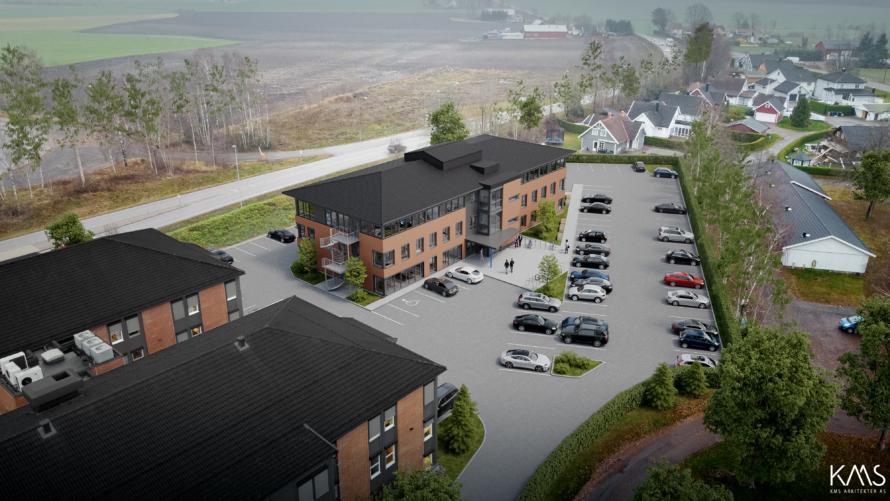 Oversiktsbilde av et moderne kontorbygg med parkeringsplass og omkringliggende landskap.