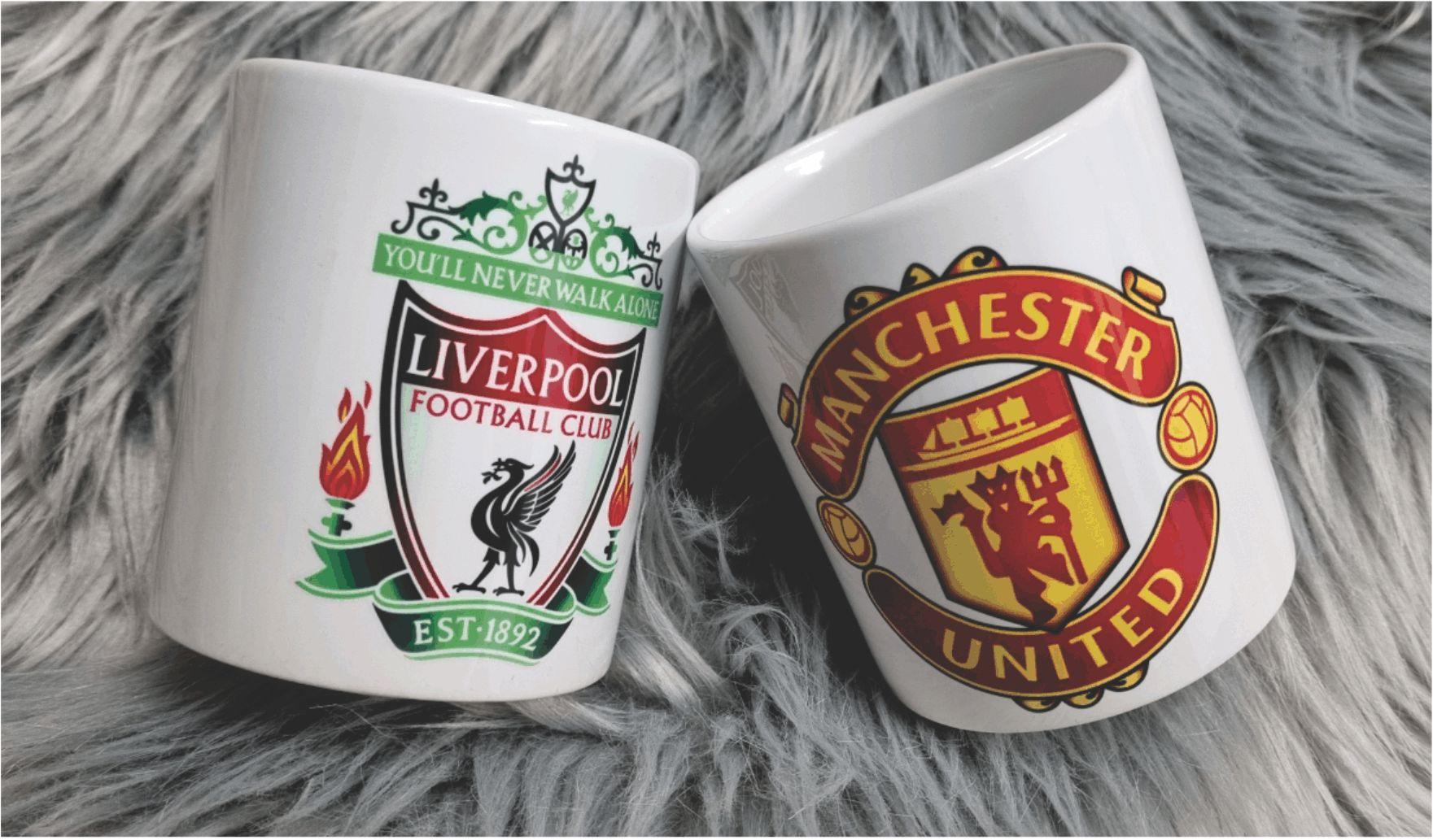 To kopper med logoene til Liverpool og Manchester United på en myk, grå pels.