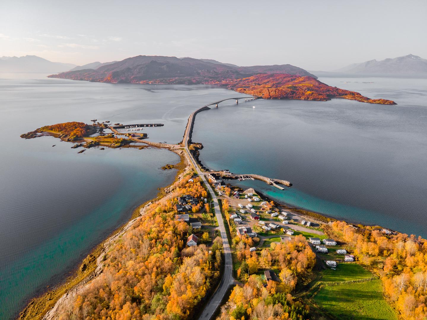 En vakker høstutsikt over en øy med broer og fargerike trær ved kysten av Norge.