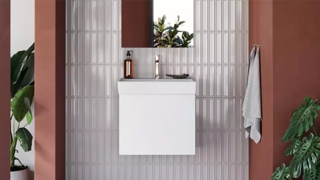 Moderne baderom med hvit servant, speil og planter på veggen i en stilren, minimalistisk design.