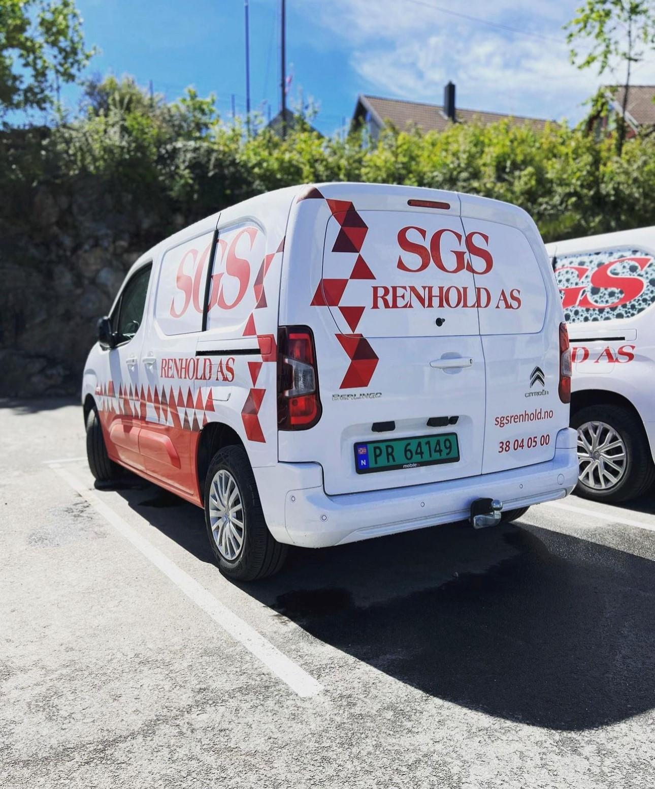 En hvit varebil med logoen til SGS Renhold AS parkert på en parkeringsplass.