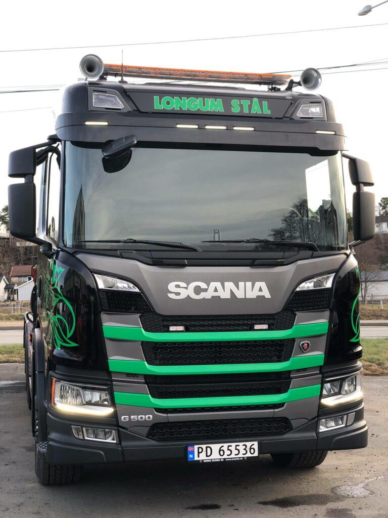 En svart Scania lastebil med grønn dekorasjon og teksten "Nordic Star" på fronten.