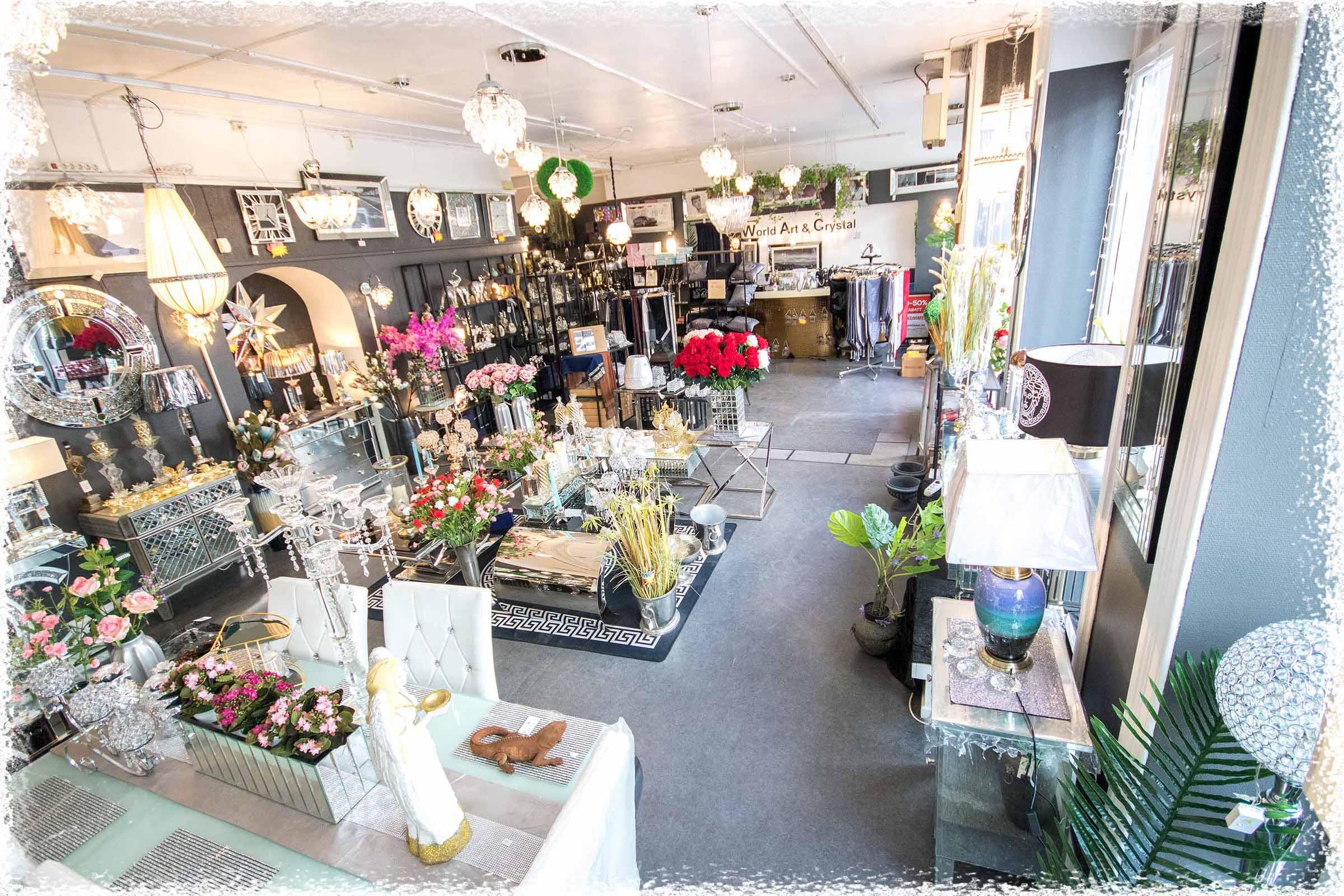 Interiør av en butikk med dekorative gjenstander, blomsterarrangementer og belysning.