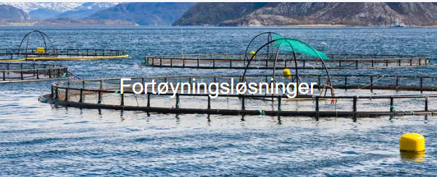 Fiskefarmer med nett og flytende bojer i en fjord med fjell i bakgrunnen.