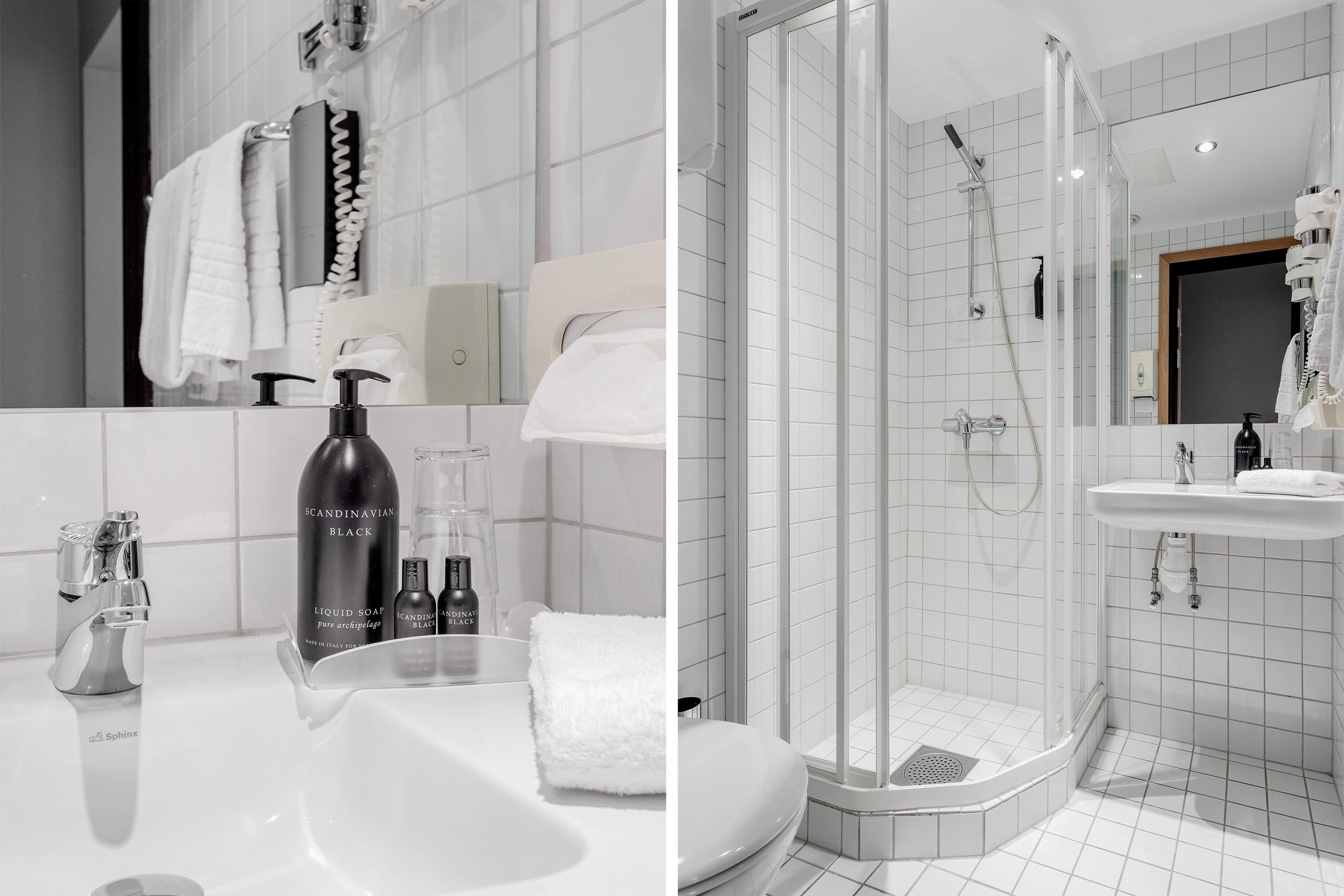 Baderom med dusj, servant, håndklær og toalett, alt i hvite fliser og moderne design.