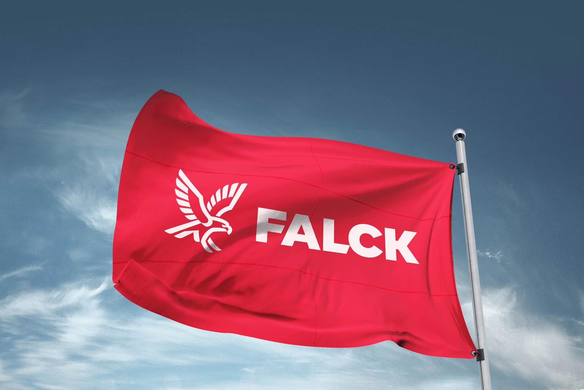 Rød flagg med hvit tekst "FALCK" og en ørn, som flagrer mot en blå himmel.