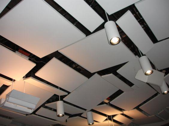 Tak med akustiske plater og spotlights i et moderne rom.