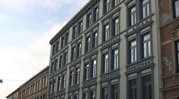 En historisk bygning med mange vinduer og detaljerte fasader i en bygate.