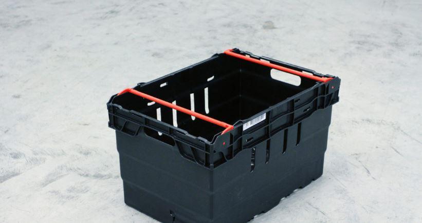 En svart plastkasse med røde håndtak, plassert på en lys overflate.