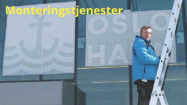 En mann står på en stige og monterer skilt på en bygning med teksten "Oslo Havn".