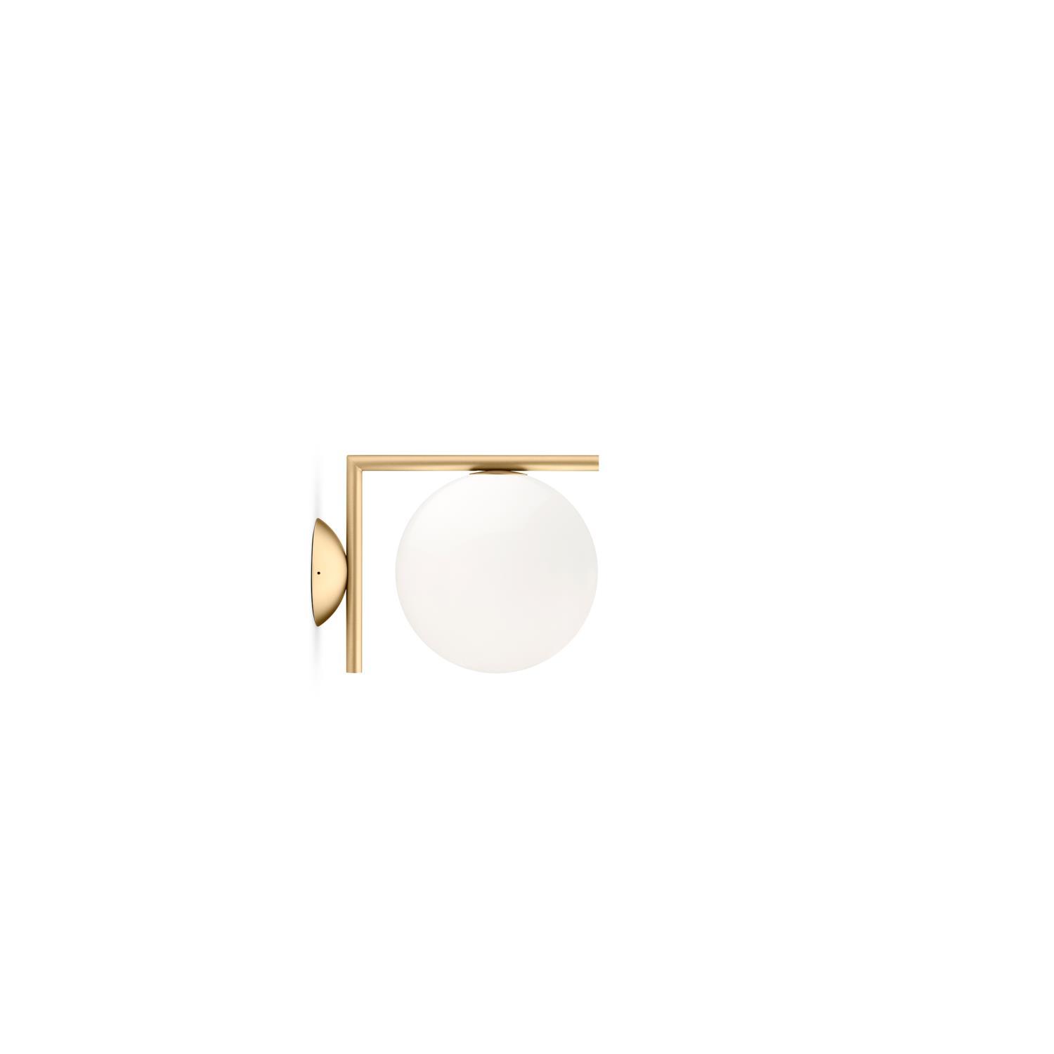 Vegglampe med gullfarget ramme og hvit glasskuppel, moderne design.