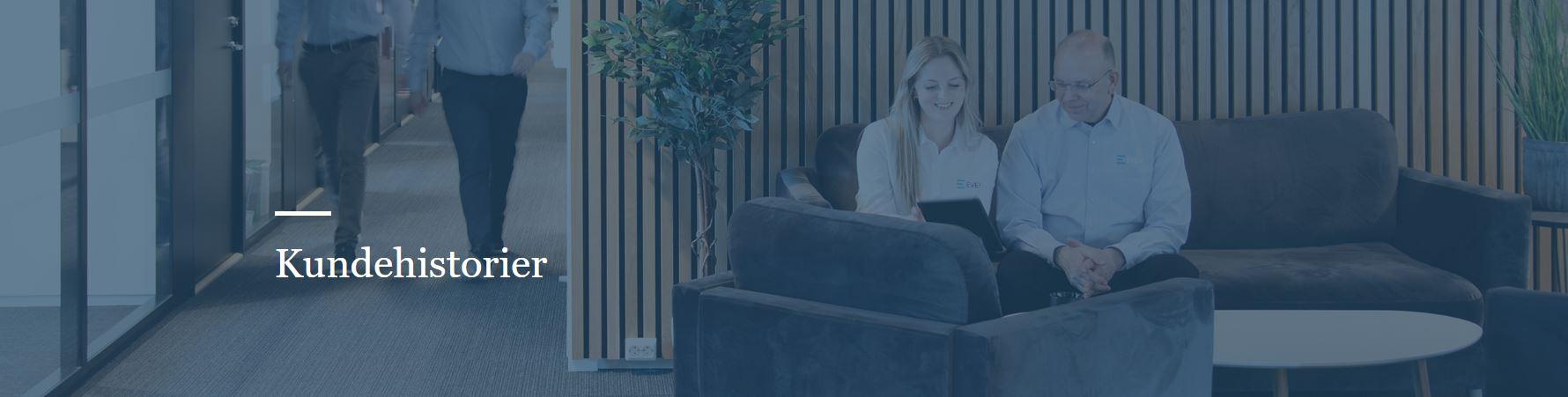 To personer sitter på en sofa i et moderne kontorlandskap med planter i bakgrunnen.