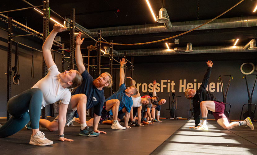 Treningsøkt med flere personer som utfører øvelser i CrossFit Heisen, med fokus på styrke og fleksibilitet.
