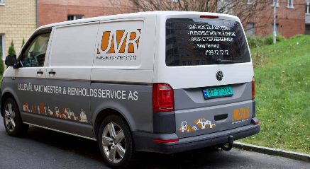 En varebil med logo og kontaktinformasjon for OVR Anleggsservice, parkert på en gate.