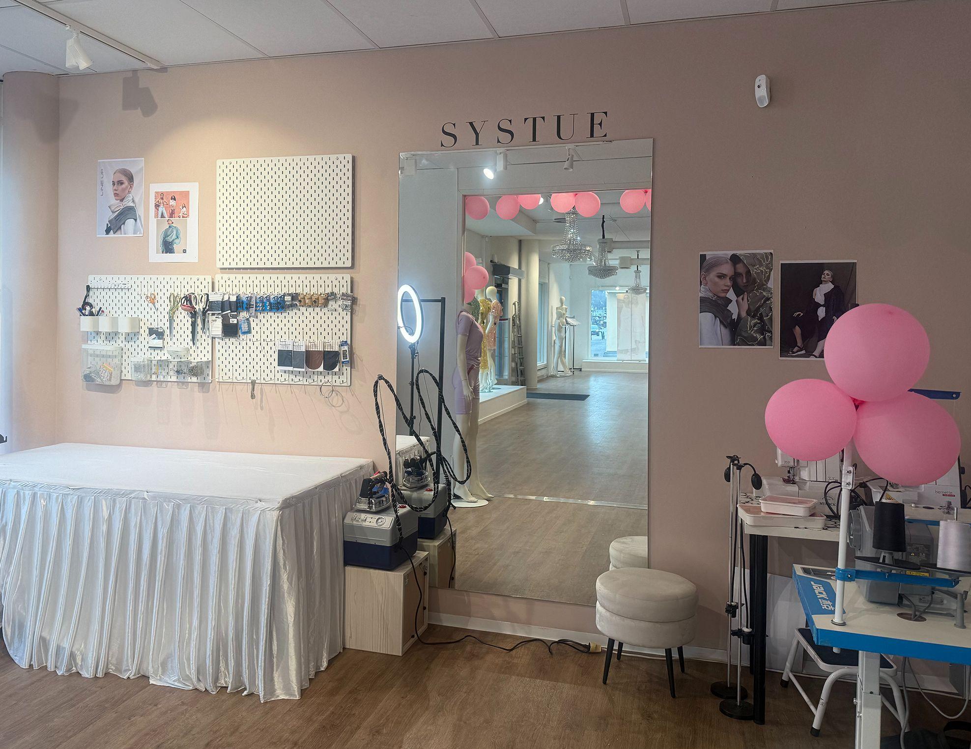 Interiør av en skjønnhetssalong med speil, rosa ballonger og utstyr til hudpleie.