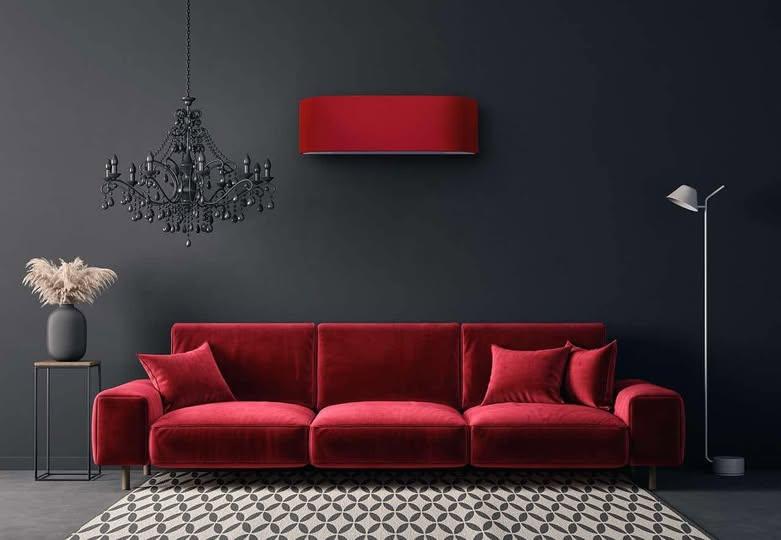 Rød sofa med puter, svart vegg, moderne lampe og krystallkrone i stilfull stueinnredning.