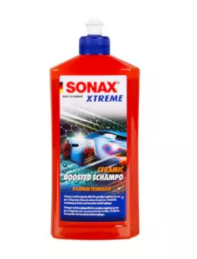 Flaske med SONAX XTREME keramisk sjampo for bilvask, med rød etikett og blå kork.