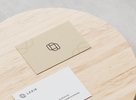 Visittkort med minimalistisk design og logo, plassert på en rund treoverflate.