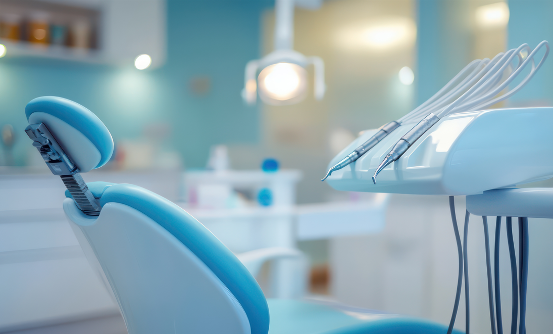 Moderne tannlegekontor med en blå tannlegestol og dentalverktøy på en hvit arbeidsflate.