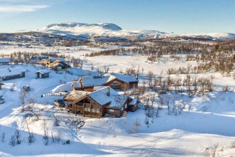 En vakker vinterutsikt over snødekte fjell og hytter i et rolig landskap.