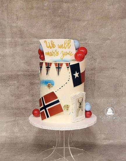 En festkake dekorert med norske og texanske flagg, røde og blå kuler, og teksten "We will meet you".