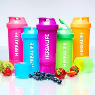 Fargerike shakerflasker fra Herbalife i rosa, grønn, blå, oransje og gul med frukt rundt.