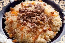 En tallerken med ris pilaf toppet med biter av kjøtt og gulrøtter, ser smakfull ut.