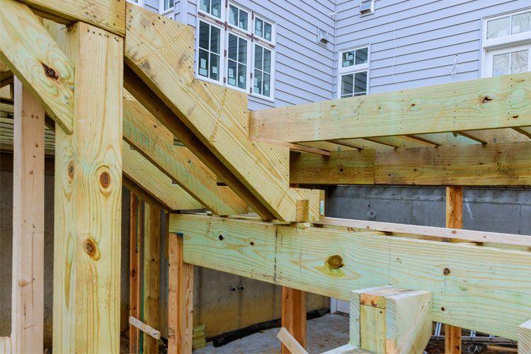 Trappen i treverk under bygging, med synlige bjelker og rammer i en ny bolig.