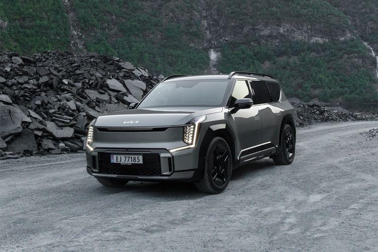 En moderne SUV parkert på en grusvei med fjell i bakgrunnen. Bilen har en sølvfarge og svarte detaljer.