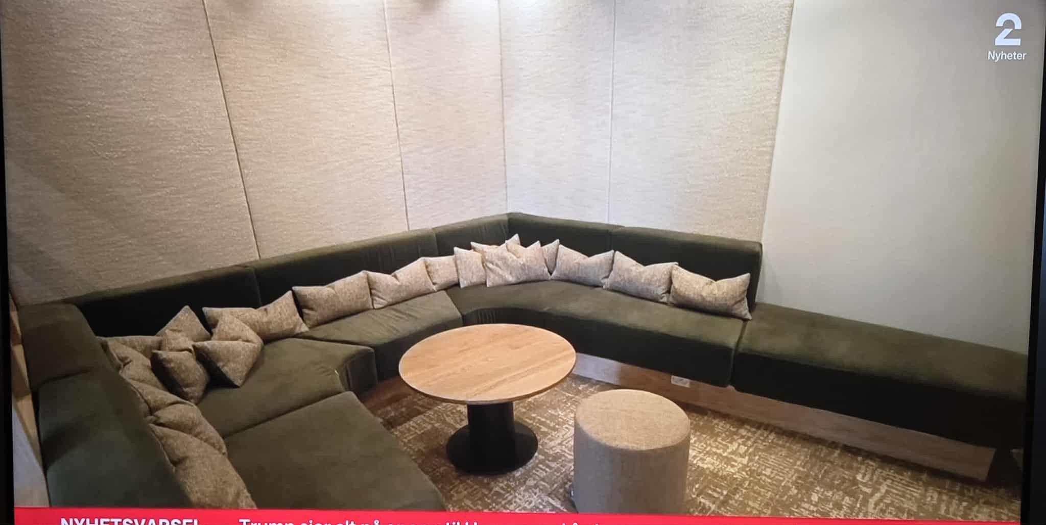 Moderne stue med en stor, grønn sofa, runde bord og puter, perfekt for avslapning og sosiale sammenkomster.