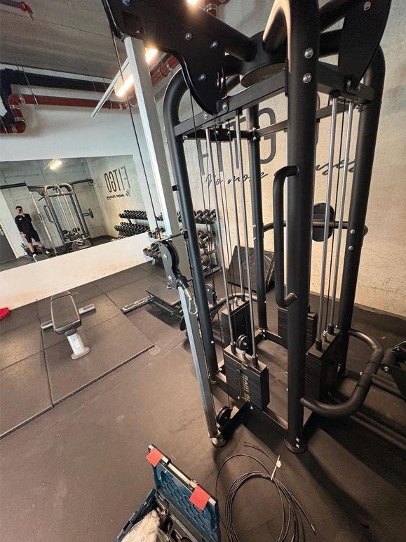 Treningsutstyr i et moderne treningsstudio med speil og benk i bakgrunnen.