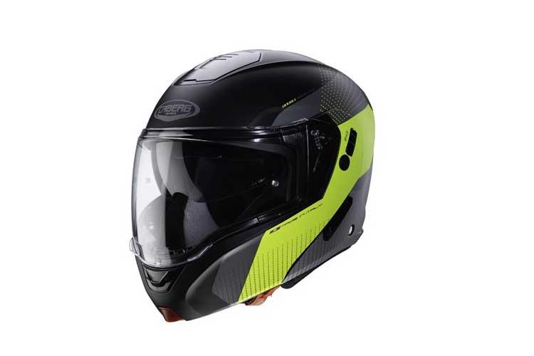 En svart og gul motorsykkelhjelm med visir og karbonfiberdesign.