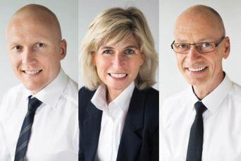 Tre profesjonelle personer med smil, iført skjorter og jakker, poserer for portrettbilder mot en lys bakgrunn.