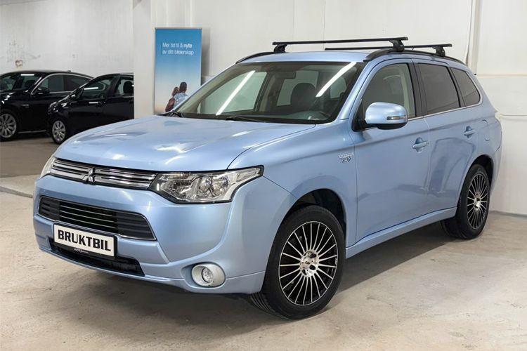 Blå Mitsubishi Outlander SUV med takstativ, stående i en bilutstilling.