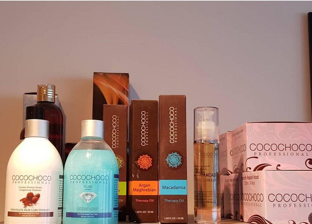 Hyller med forskjellige hårpleieprodukter, inkludert sjampo, balsam og stylingprodukter i elegante emballasjer.