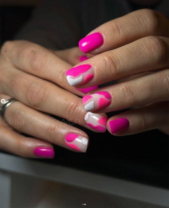 Hender med fargerik neglelakk i rosa og hvitt, med et moderne design og glansfull finish.
