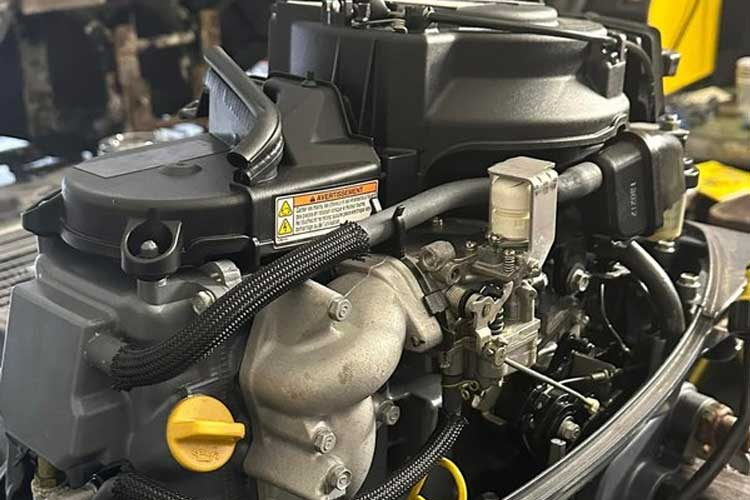 Bilde av en motor med detaljerte komponenter, inkludert slanger, ventiler og en gasskarburator.