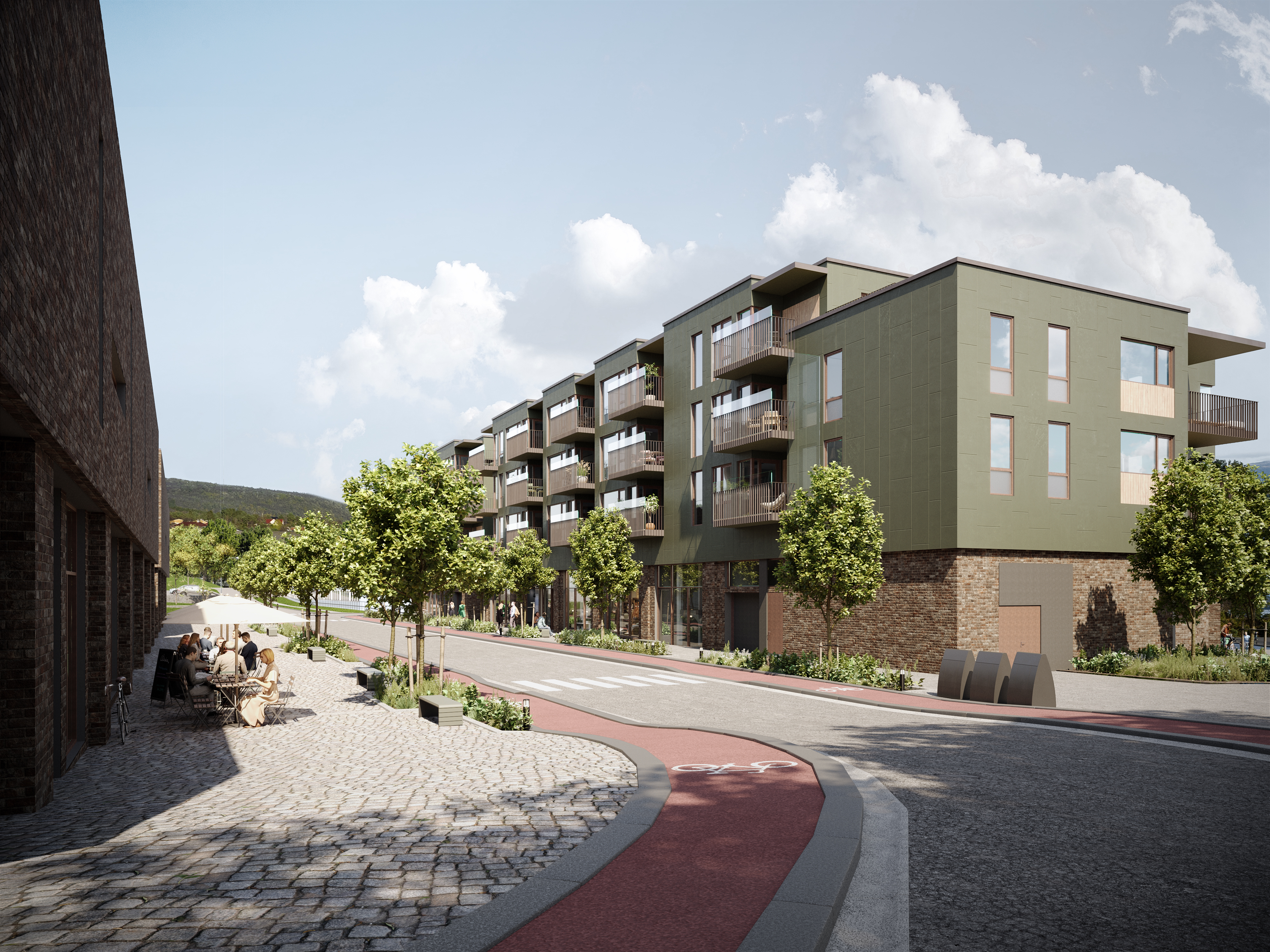 Moderne leilighetskompleks med grønne fasader og trær langs en brosteinsbelagt gate.
