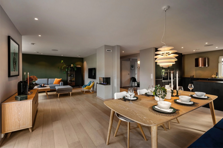 Moderne stue med spisebord, stoler, sofa og dekorative elementer i en lys og stilren leilighet.