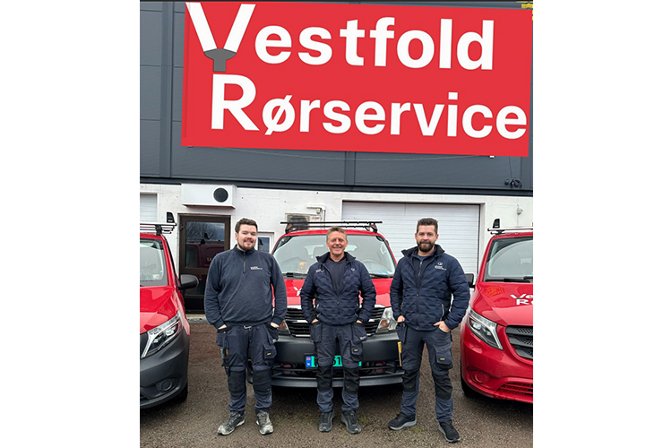 Tre ansatte fra Vestfold Rørservice står foran en rød bil og bygningen med logoen synlig.